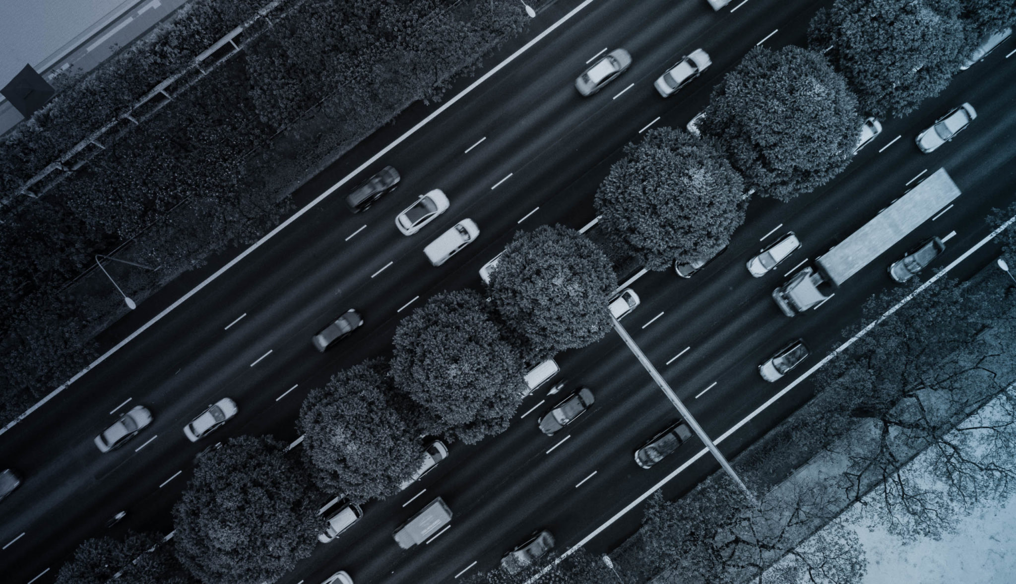 aerial view of highway with trees in the median