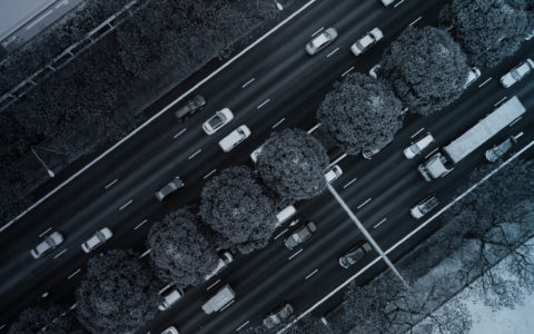 aerial view of highway with trees in the median